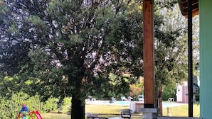A covered outdoor area with a picnic table and chairs, a playground with a slide, and a large tree. - Wonderful private villa with WIFI, A/C, private pool, patio and pets allowed, close to Lucca (Orentano)