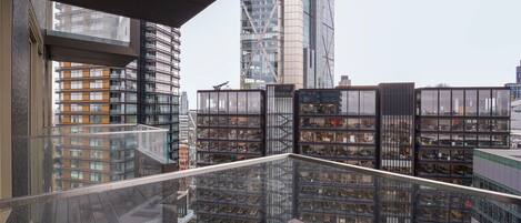 Ein Hochhaus mit Glasbalkon und Blick auf die Skyline.