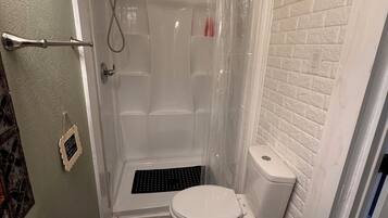 A bathroom with a shower, toilet, and sink.