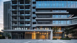 A modern building with a prominent SOMERSET sign, featuring a multi-story structure with a mix of glass and concrete elements.
