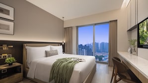 A modern hotel room with a large bed, a desk, and a city view. - Somerset Pudong Riverside Shanghai (Shanghai)