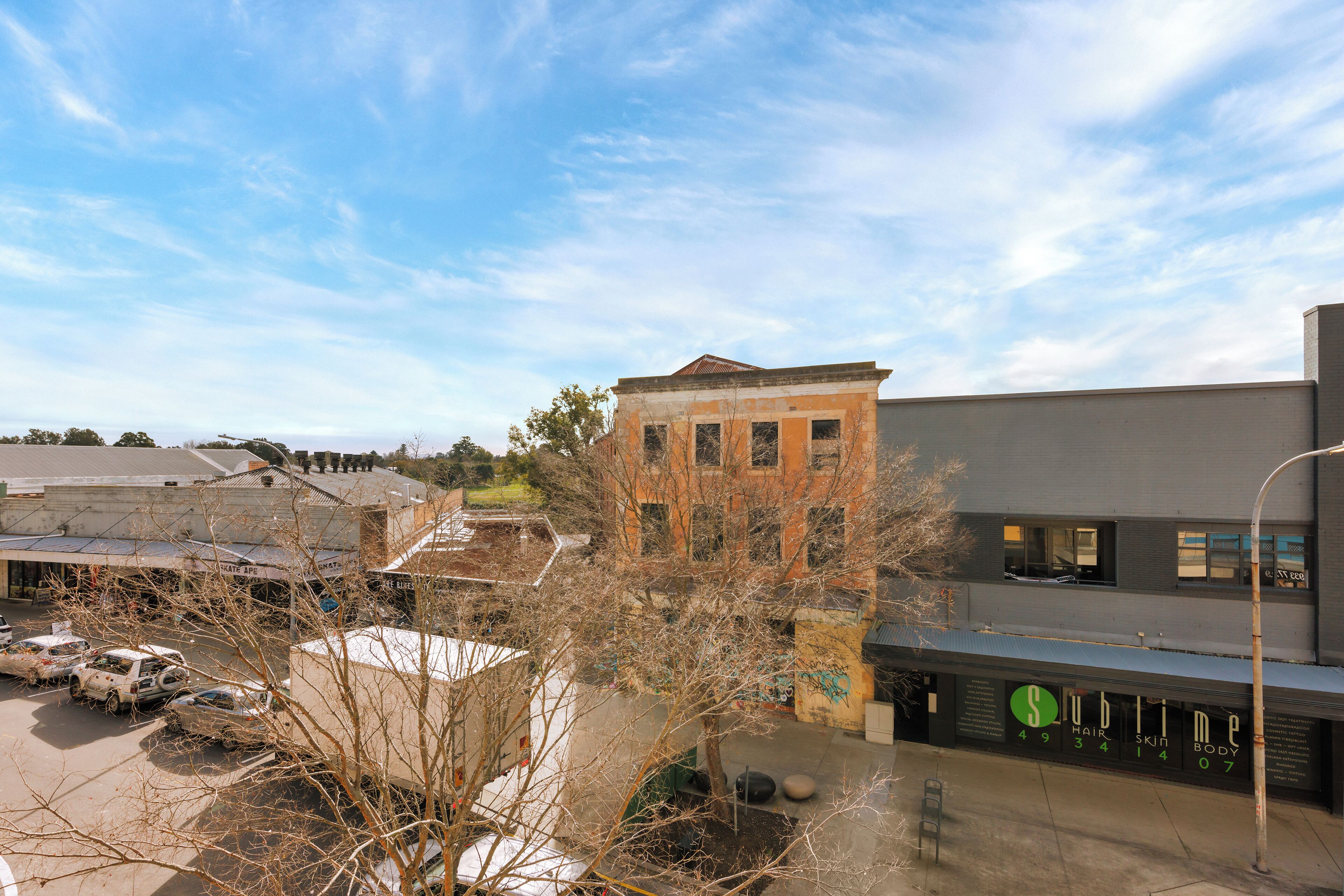 A commercial building with a storefront and a parking lot.
