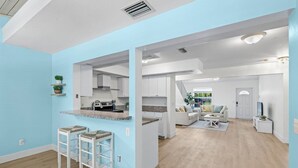 Un appartement moderne comprenant une cuisine, un coin repas et un salon.