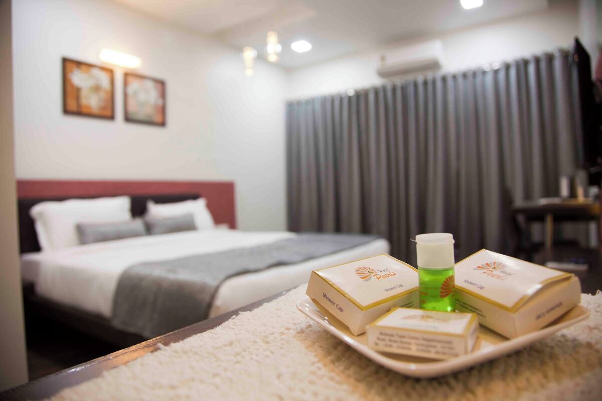 Ein Hotelzimmer mit einem ordentlich bezogenen Bett, einem Tablett mit Pflegeprodukten und Blick ins Zimmerinnere.