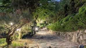 A stone pathway flanked by trees and moss-covered walls, leading to a distant structure. - Pocheon Luxjay pet Pension (Pocheon)