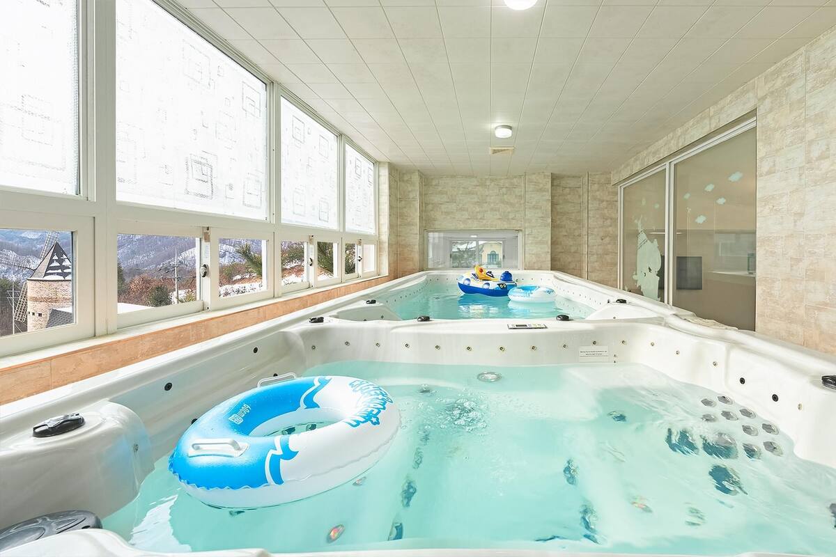 Un área de spa con dos jacuzzis, uno con un aro inflable azul.