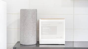 A white dishcloth and a box of day&day Premium Dishcloth on a dark surface against a white tiled wall.