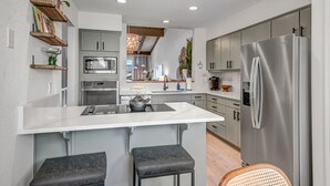 A modern kitchen with a central island, stainless steel appliances, and bar stools. - Experience luxury at Sedona Tanglewood Treasure, a 2BR oasis in Village of Oak Creek. (Sedona)
