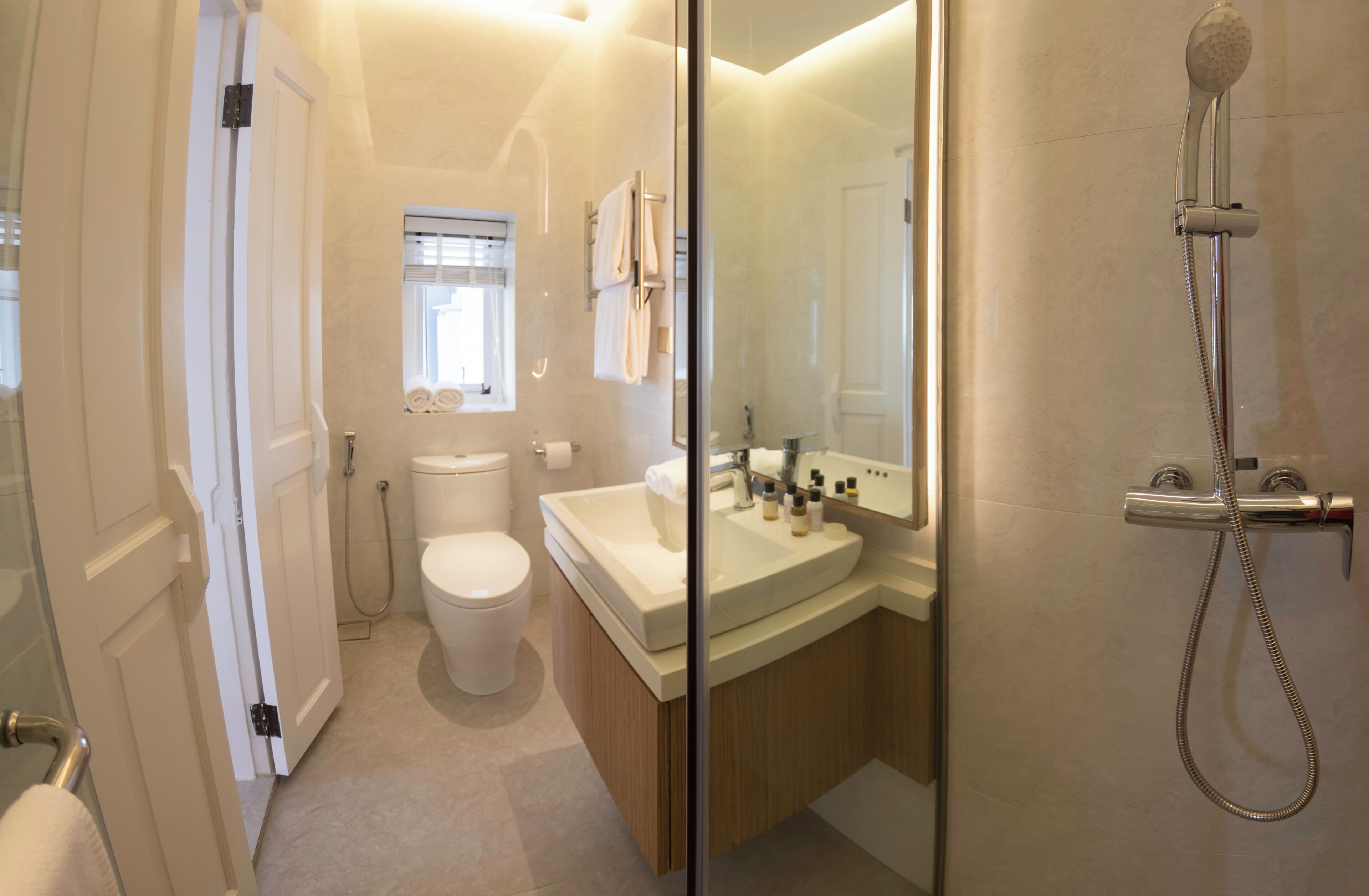 A bathroom with a toilet, sink, and shower.