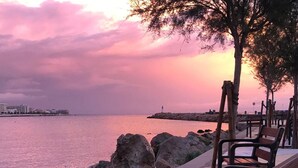 A bench by a waterfront with a sunset view.