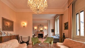 A spacious living room with a chandelier, two sofas, a round table, and a fireplace. - Aspromonte Garden House by Interhome (Milan)
