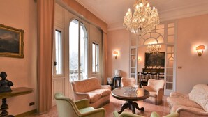 A spacious room with a chandelier, comfortable seating, and large windows. - Aspromonte Garden House by Interhome (Milan)