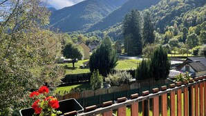 Eine Berglandschaft mit Holzzaun und einem Haus im Vordergrund.