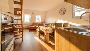 A kitchen with wooden cabinets, a built-in oven, and a sink. - Cozy Bovec Apartment in Soča Valley, Bovec, Slovenia (Bovec)
