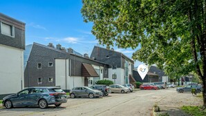 A residential street with houses, parked cars, and a clear sky. - Cozy Bovec Apartment in Soča Valley, Bovec, Slovenia (Bovec)