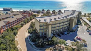 Un hotel con tetto curvo, diversi balconi e un parcheggio.