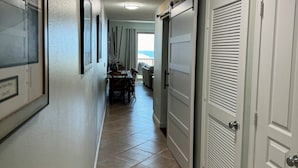 Un corridoio con zona pranzo, porte scorrevoli e vista sull'esterno.