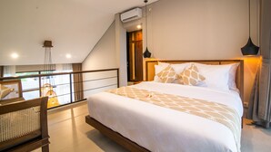 Ein modernes Schlafzimmer mit einem großen Bett, einem Holzkopfende und einem Balkon mit Blick.