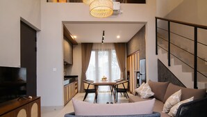 Ein modernes Wohnzimmer mit einer Couch, einem Esstisch und einem Fernseher.