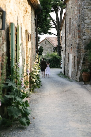 A narrow cobblestone alley flanked by stone buildings with a rustic charm.