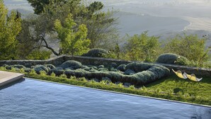 A swimming pool with a stone wall and a view of a valley. - Monteverdi Tuscany (Sarteano)