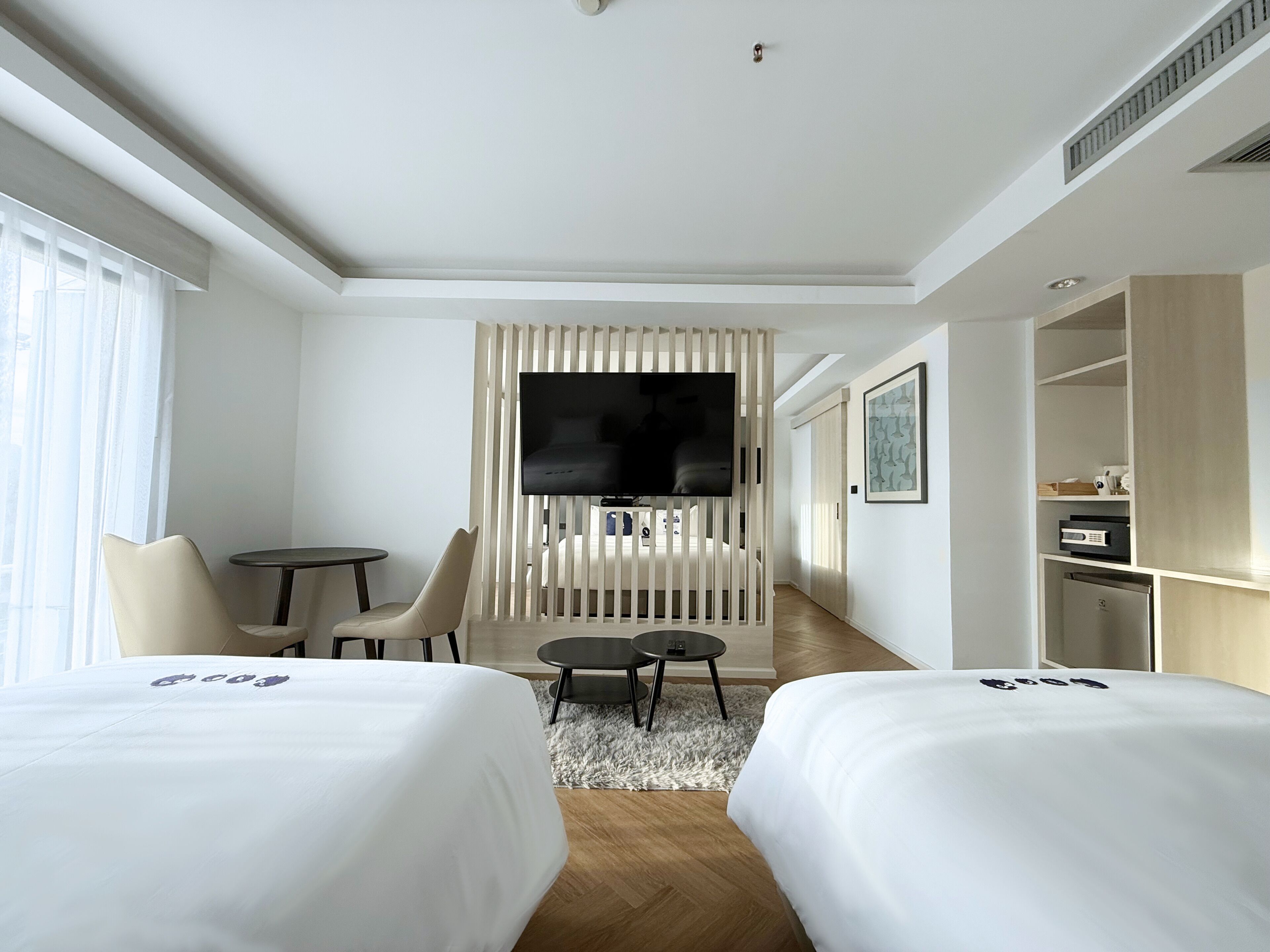 Una habitación de hotel con dos camas, televisión, escritorio y armario.