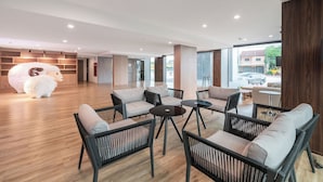 A modern lounge area with sofas, chairs, and tables.