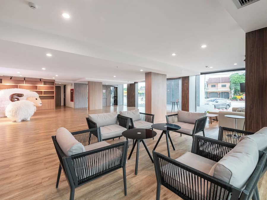 Un área de estar moderna con sofás, sillones y mesas.