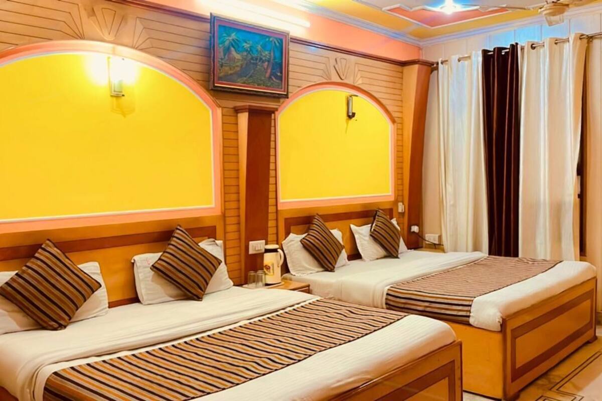 A hotel room with two beds, wooden headboards, and a painting on the wall.