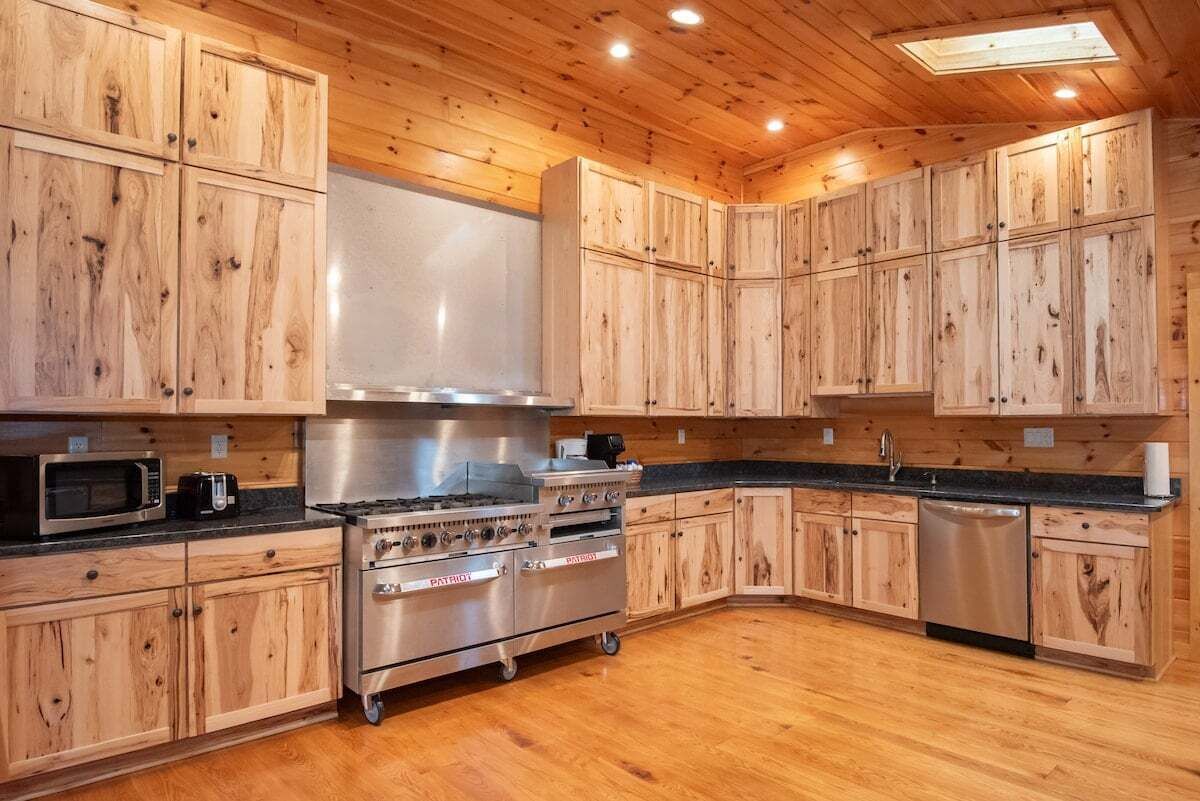 A kitchen with wooden cabinets, a stainless steel stove, and a dishwasher.