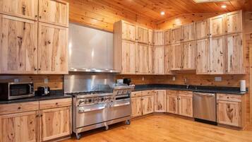 A kitchen with wooden cabinets, a stainless steel stove, and a dishwasher.