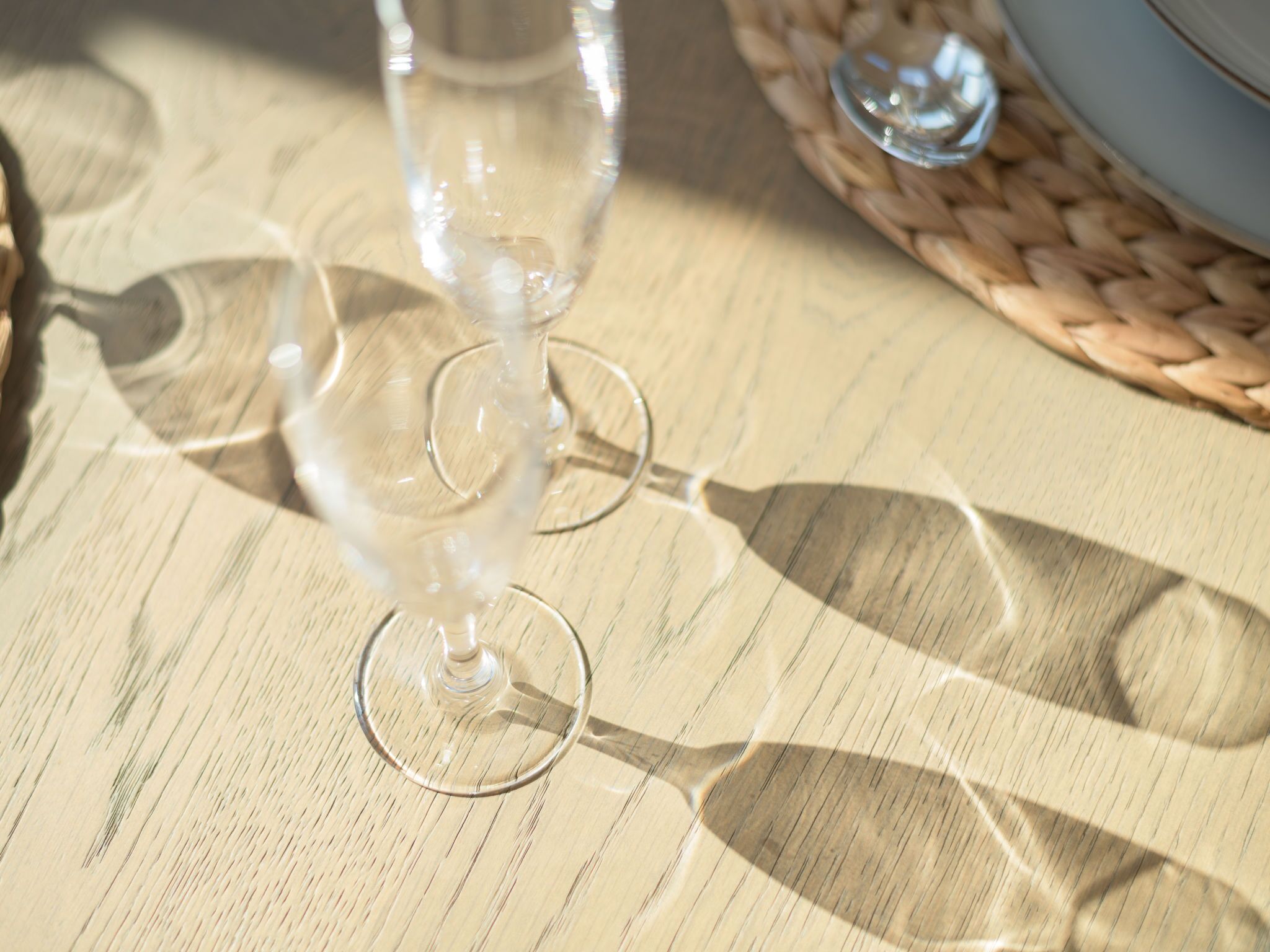 A clear glass of water on a woven tablecloth.