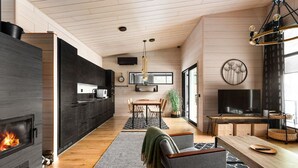 A modern kitchen with a built-in stove, wooden cabinets, and a large window.