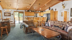Un accogliente interno di lodge con arredi in legno, zona pranzo e cucina.