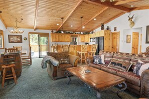 Een knus ingerichte lodge met houten meubels, een eethoek en een keuken.