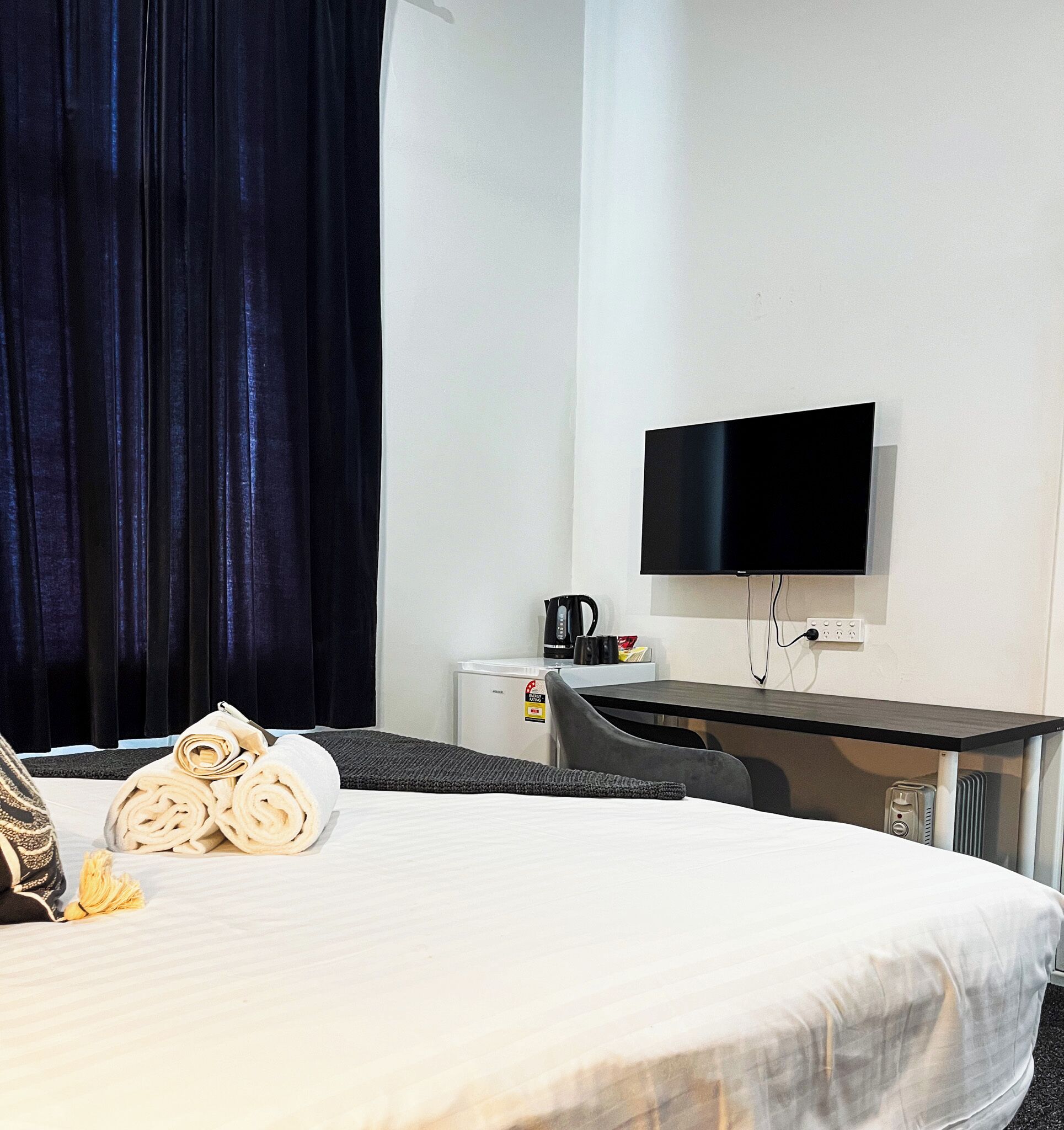 A hotel room with a bed, a desk, a television, and a coffee maker.