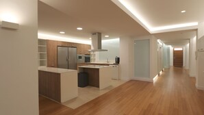 Une cuisine moderne avec des meubles en bois, un îlot central et des appareils électroménagers intégrés.
