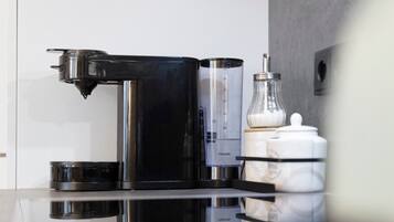 A modern kitchen with a coffee machine, a scale, and storage jars.
