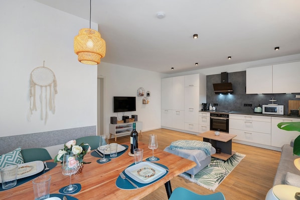 A modern kitchen with white cabinets, a microwave, and an oven.