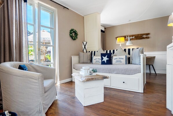 Ein gemütliches Wohnzimmer mit einer Couch, einem Couchtisch und einem Schreibtisch.