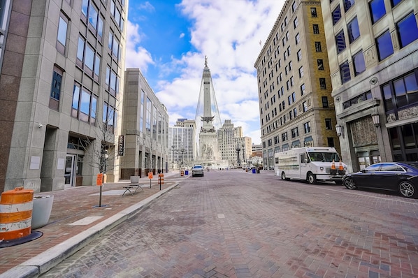 A city street with historic buildings, a prominent tower, and a parked truck.