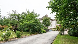 A residential driveway leading to a house with a sloped roof, surrounded by lush greenery and a well-maintained lawn. - Holiday Apartment "Am Wald Dachgeschoss" with Shared Terraces, Shared Garden & Wi-Fi (Krauschwitz)