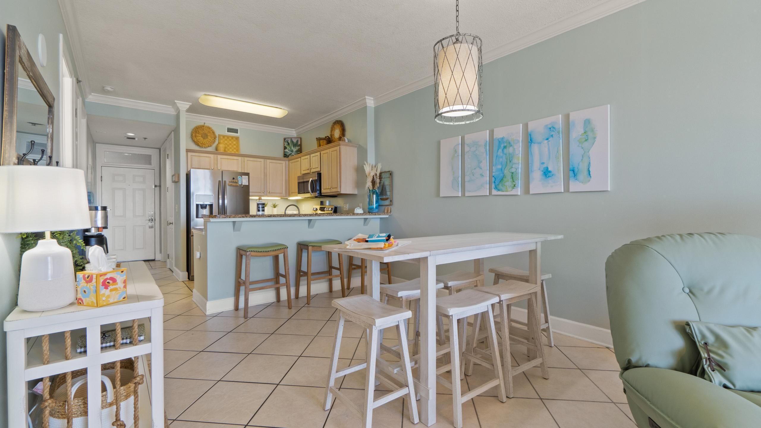 Uma cozinha moderna com uma ilha central, banquetas de madeira e uma mesa de jantar.