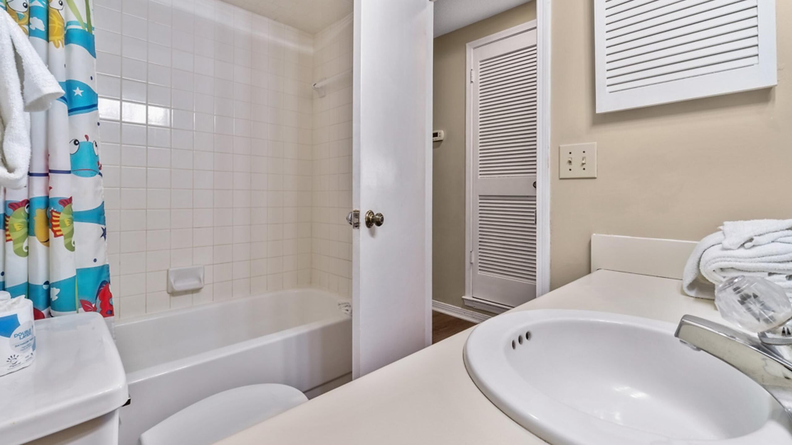 A bathroom with a bathtub, toilet, and sink.