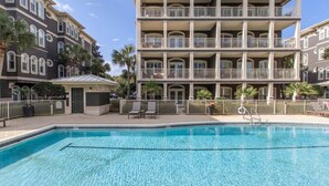 A pool area with a clear blue pool, surrounded by a fence, and adjacent to a multi-story building with balconies. - Steps to Pool & (Private) Beach! Beach Service Included! 2 Adult Bikes! - Blue Crab Villa on 30A (Santa Rosa Beach)