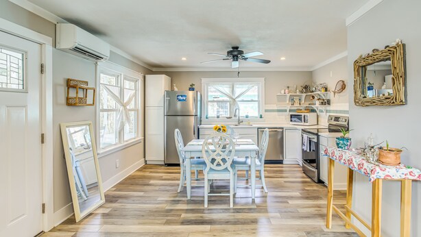 A kitchen with a dining table, chairs, and a ceiling fan. - 1 Mi to Beach: Sustainable Oak Island Home! (Oak Island)