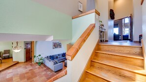 A spacious living area with a wooden staircase, a sofa set, and a dining area. - 1-Acre Backyard & Gym: Spacious Apopka Escape! (Apopka)