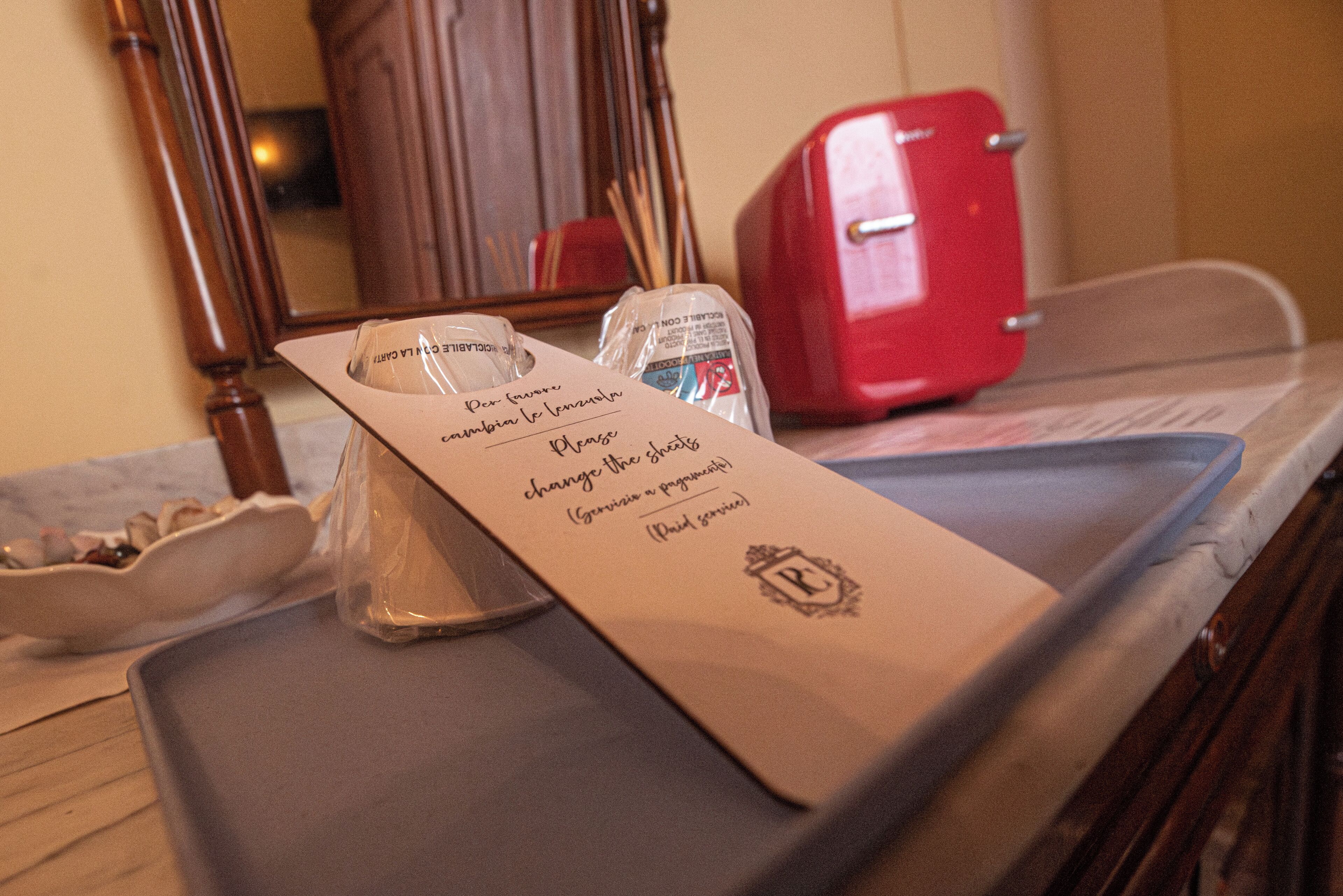 Ein Tablett mit einer Speisekarte, einem roten Toaster und einem Holzkabinett im Hintergrund.
