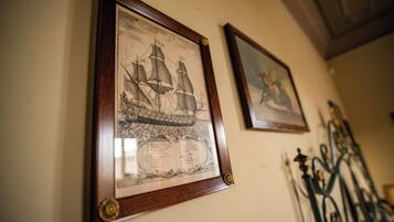 Dos ilustraciones históricas marítimas enmarcadas en una pared.