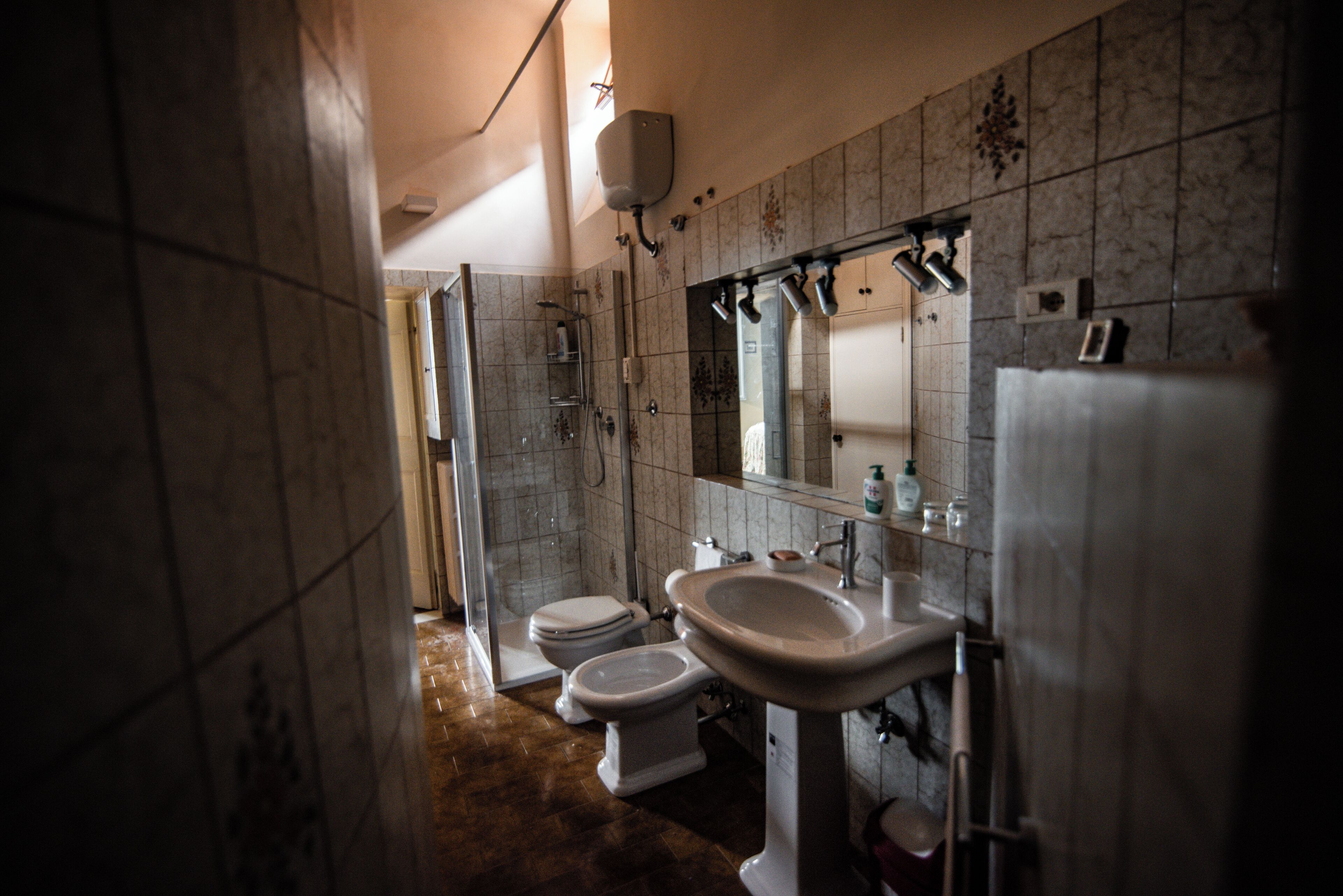 A bathroom with a toilet, sink, and shower.